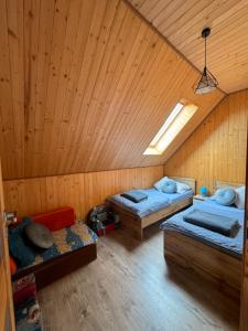 um quarto com 3 camas num quarto de madeira em Domki całoroczne KATRINA em Krynica Morska
