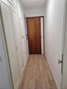 einen Flur mit Tür und Holzboden in der Unterkunft Appartement traversant ensoleillé in Boulogne-Billancourt