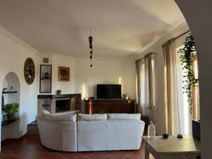 uma sala de estar com um sofá branco e uma televisão em B&b filì Al casale 1121 em Roma