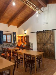 ローマにあるB&b filì Al casale 1121の木製のテーブルと椅子、納屋のドアが備わるレストラン