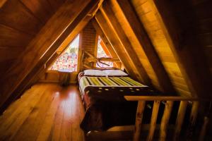 a small room with a bed in a attic at Canto del Bosque Santuario de las luciernagas in Nanacamilpa