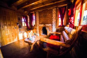 a living room with a fireplace in a log cabin at Canto del Bosque Santuario de las luciernagas in Nanacamilpa