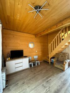 a room with a ceiling fan and a desk with a tv at Domki całoroczne KATRINA in Krynica Morska
