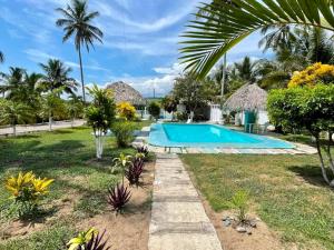 un complexe avec une piscine et des palmiers dans l'établissement Hotel Costa Belle, à Monte Gordo