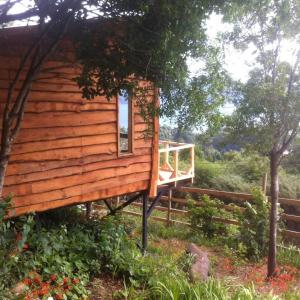 a log cabin with a porch and a window at CABAÑAS ALTO BELLAVISTA NIEBLA in Niebla