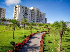 uma passarela num parque com palmeiras e flores em Lagoa Flat Service RM Hopsedagem em Caldas Novas