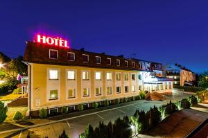 un hôtel avec un panneau de néon en haut dans l'établissement Hotel Zielonki, à Zielonki