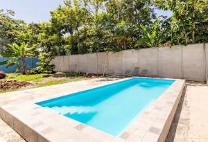 una piscina con 2 sillas y una valla en bungalow cactus frente ala playa, en Cahuita