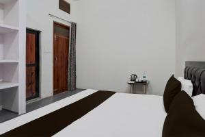- une chambre avec un lit et une porte en bois dans l'établissement OYO Atithi Guest House, à Kāshīpur