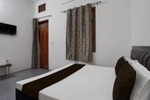 - une chambre avec un lit et une fenêtre dans l'établissement OYO Atithi Guest House, à Kāshīpur