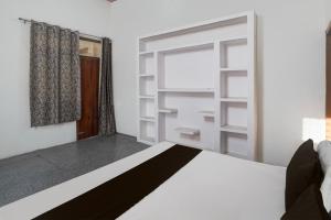 - une chambre avec un lit blanc et une fenêtre dans l'établissement OYO Atithi Guest House, à Kāshīpur