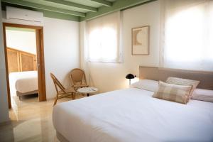 a bedroom with a large white bed and a window at Rooms by JovA in El Campello