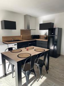 a kitchen with a table with chairs and a refrigerator at Maison de 40m2 avec jardin de 50m2 in Orange +2 photos