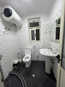 a white bathroom with a toilet and a sink at Apartament Qetesia in Çorovodë +41 photos