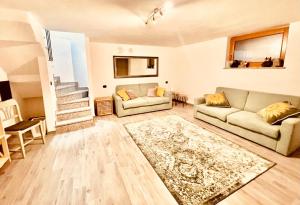 una sala de estar con 2 sofás y una alfombra en La Sellerie, en Nus
