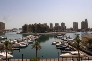 un gruppo di barche attraccate in un porto con edifici di 2 BHK Townhouse at Pearl a Doha