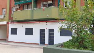 a white garage with two doors and a building at Sevilla Urban Flat in Seville