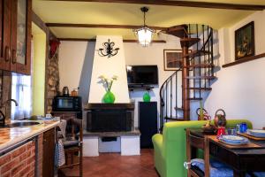 sala de estar con sofá verde y escalera de caracol en Ca' Tonino en Bagnone