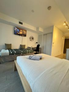 a hotel room with two beds and a desk at Jarvis Apartment in Toronto