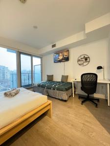 a bedroom with two beds and a desk and a chair at Jarvis Apartment in Toronto