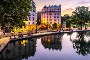 a river in a city with buildings in the background at L'Opaline ~ T2 Calme ~ Proche Métro Idéal pour JO in Paris