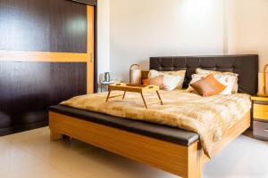 a bedroom with a large bed with a table on it at Appartement African Chic in Dakar