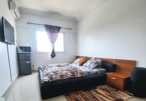 a small bedroom with a bed and a window at Appartement African Chic in Dakar