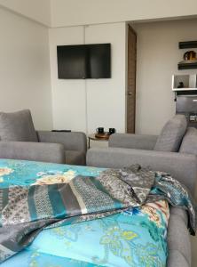 a living room with two couches and a flat screen tv at Appartement African Chic in Dakar