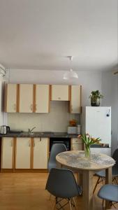 uma cozinha com uma mesa e um frigorífico branco em Apartament 35 em Zamość