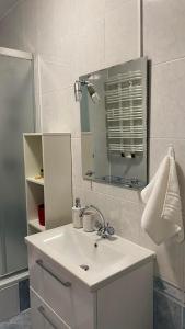 a white bathroom with a sink and a mirror at Apartament 35 in Zamość