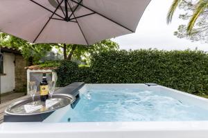 a hot tub with a bottle of wine and an umbrella at Villa Del Rubbio in Rome