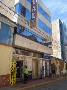 dos hombres parados frente a un edificio en HOSTAL ACUARIUS PUNO, en Puno