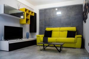 a yellow couch in a living room with a tv at App castle view Montefalcione in Montefalcione