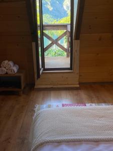 um quarto com uma grande janela e um colchão no chão em Agora Farmhouse em Koman