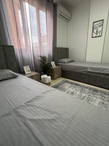 um quarto com 2 camas e uma janela em Hostel by Fenix Tirana em Tirana