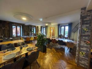una sala da pranzo con tavoli, sedie e un muro di mattoni di Hôtel Restaurant Valneige a Mittlach