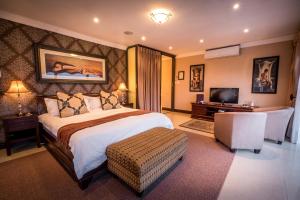 a hotel room with a bed and a television at Château La Mer Exclusive Guesthouse & Spa in Hartbeespoort +46 photos