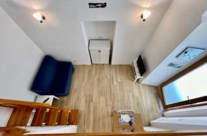 an attic room with a staircase and a blue couch at La Stalla in Porto Santo Stefano