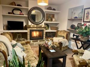 a living room with a fireplace and a couch at Casa Rubito el Olmo in Villanueva de la Concepción