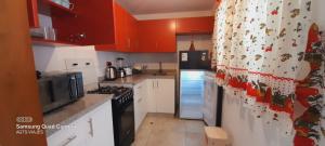 una cocina con armarios rojos y encimeras blancas en HOSPEDAJE TURISTICO CHORRILLOS Sueños de Luna INN en Lima