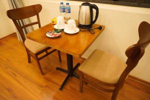 einen Holztisch mit einem Wasserkocher und einem Stuhl in der Unterkunft A Thía homestay in Diện Biên Phủ