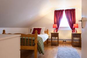 1 dormitorio con 1 cama y una ventana con cortinas rojas en Carna Chalet, en Galway