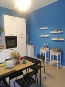 Le Solite Holiday Rooms في سانت أوفيميا لاميتسيا: مطبخ مع طاولة وكراسي وجدار ازرق