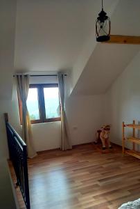 una camera da letto con una grande finestra e un pavimento in legno di Zlatna Jabuka Lux a Prijepolje