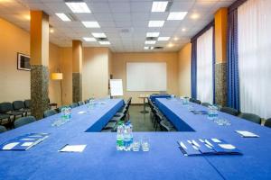 uma sala de conferências com longas mesas e cadeiras azuis em Warzkowizna em Rząsawa