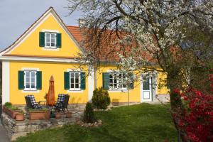 une maison jaune avec volets verts dans l'établissement Ferienhaus Planetz, à Kaindorf