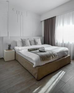 a bedroom with a large bed with a large window at Heritage & Tales: Sihna in Litochoro