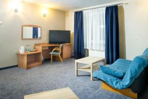 a living room with a blue couch and a television at Warzkowizna in Rząsawa