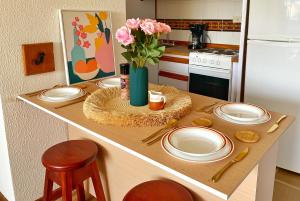 a kitchen counter with plates and a vase of flowers at Palma Sol in Pampatar