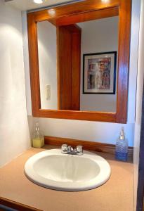 a bathroom sink with a large mirror above it at Palma Sol in Pampatar